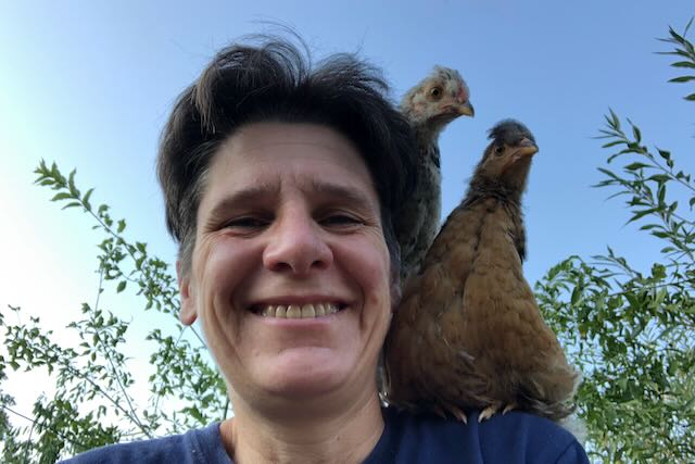 Gaëlle souriante, avec 2 jeunes poulets perchés sur son épaule